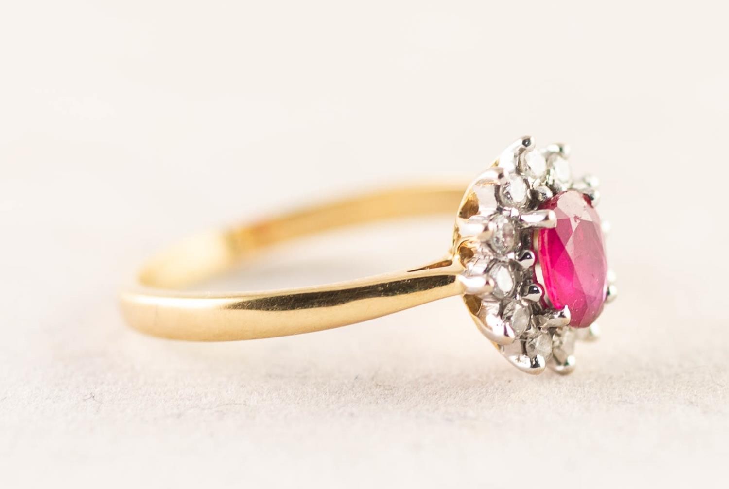 18ct GOLD, RUBY AND DIAMOND OVAL CLUSTER RING set with an oval centre ruby and surround of twelve - Image 2 of 3