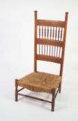 POSSIBLY AMERICAN, CARVED OAK SPINDLE BACKED NURSING CHAIR WITH WOVEN SEAGRASS SEAT, the high back