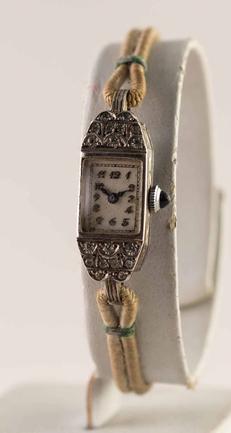 1950's WHITE METAL PASTE SET LADY'S WRISTWATCH with blue stone set winding button and Arabic dial,