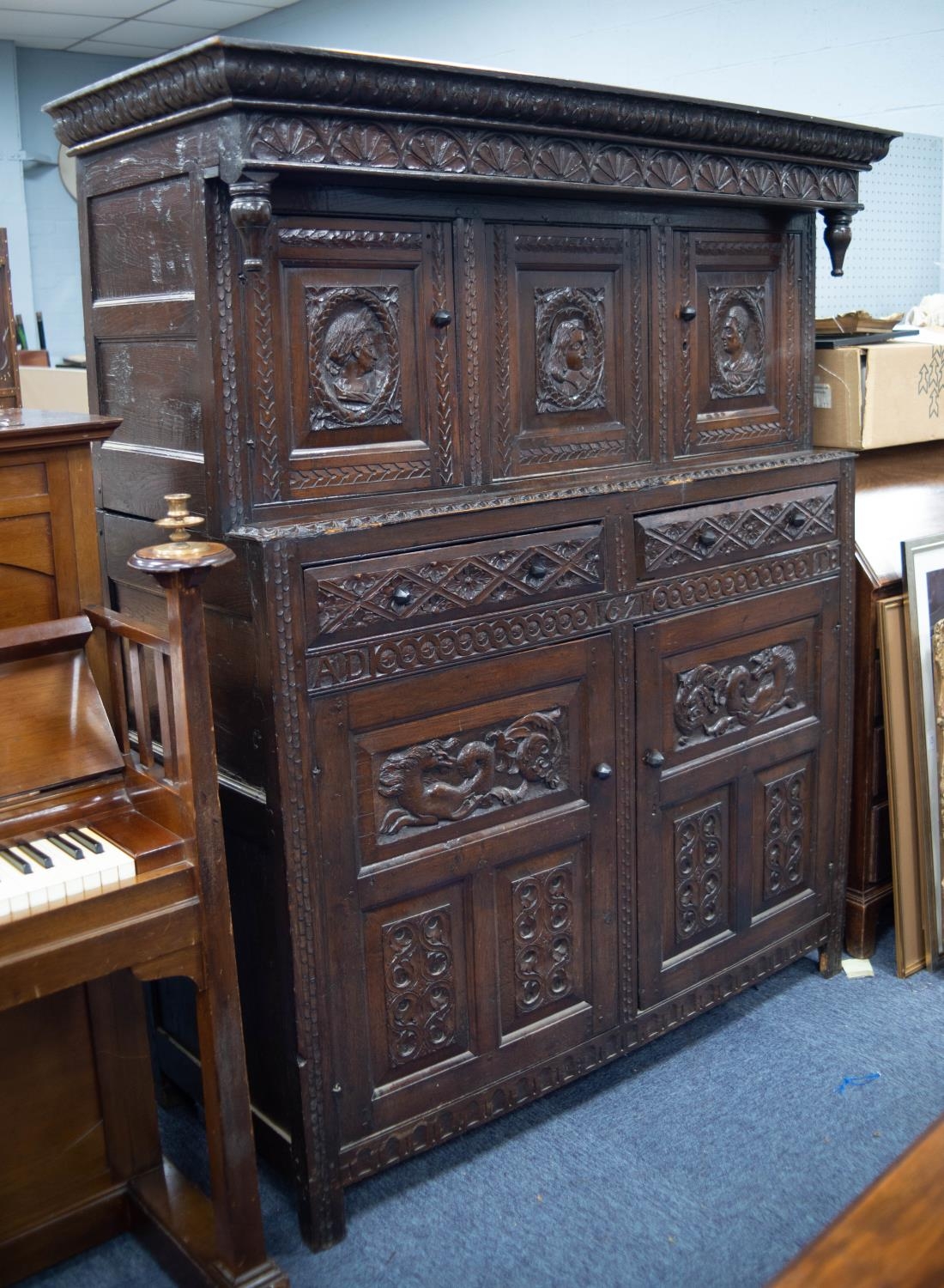 LATE 17th CENTURY CARVED OAK TWO-PART COURT CUPBOARD with later carved decoration of heads in