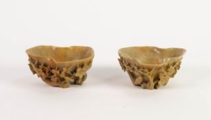 TWO SIMILAR CHINESE CARVED GREEN SOAPSTONE LIBATION CUPS, each carved with birds and flowering