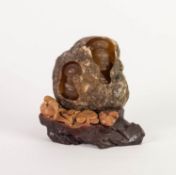 TWENTIETH CENTURY CARVED SOAPSTONE ORNAMENT DEPICTING A SEATED BUDDAH INSIDE A ROCK, with birds