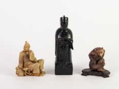 THREE CHINESE CARVED SOAPSTONE FIGURES, comprising: one modelled as an EMPEROR, in ceremonial robes,