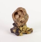 TWENTIETH CENTURY CARVED SOAPSTONE ORNAMENT DEPICTING A SEATED SAGE INSIDE A ROCK, with flowers