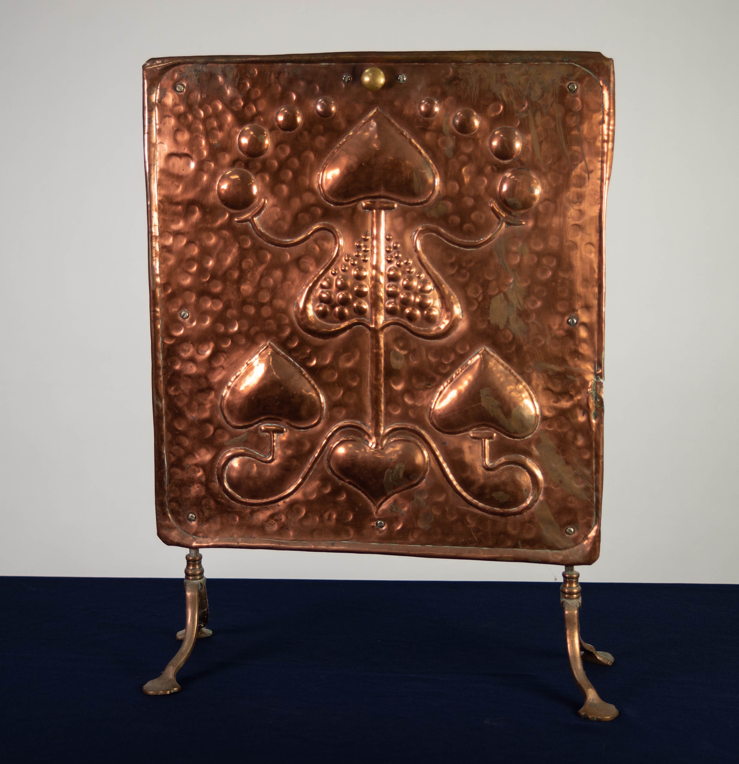 ARTS & CRAFTS PERIOD EMBOSSED COPPER GRATE SCREEN, stylised floral design, mounted on wrought