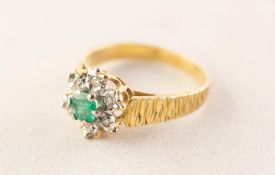 18ct GOLD RING, centrally set with a tiny emerald within a surround of six tiny illusion set
