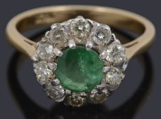 An emerald and diamond set cluster ring