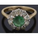 An emerald and diamond set cluster ring