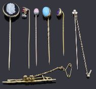 Six assorted stick pins and a bar brooch