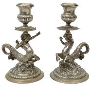 A pair of Italian silver cast candlesticks in the form of centurion sea gods (ichthyocentaurs)