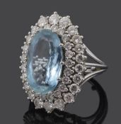 A large oval aquamarine and diamond cluster ring