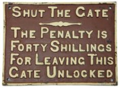 A vintage cast iron sign displaying 'SHUT THE GATE'