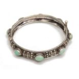 A cabochon jade and white metal hinged bangle