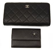 A black quilted Chanel purse and a small Chanel card case