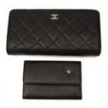 A black quilted Chanel purse and a small Chanel card case