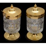 A pair of continental gilt metal and moulded crystal preserve pots and covers, (2)