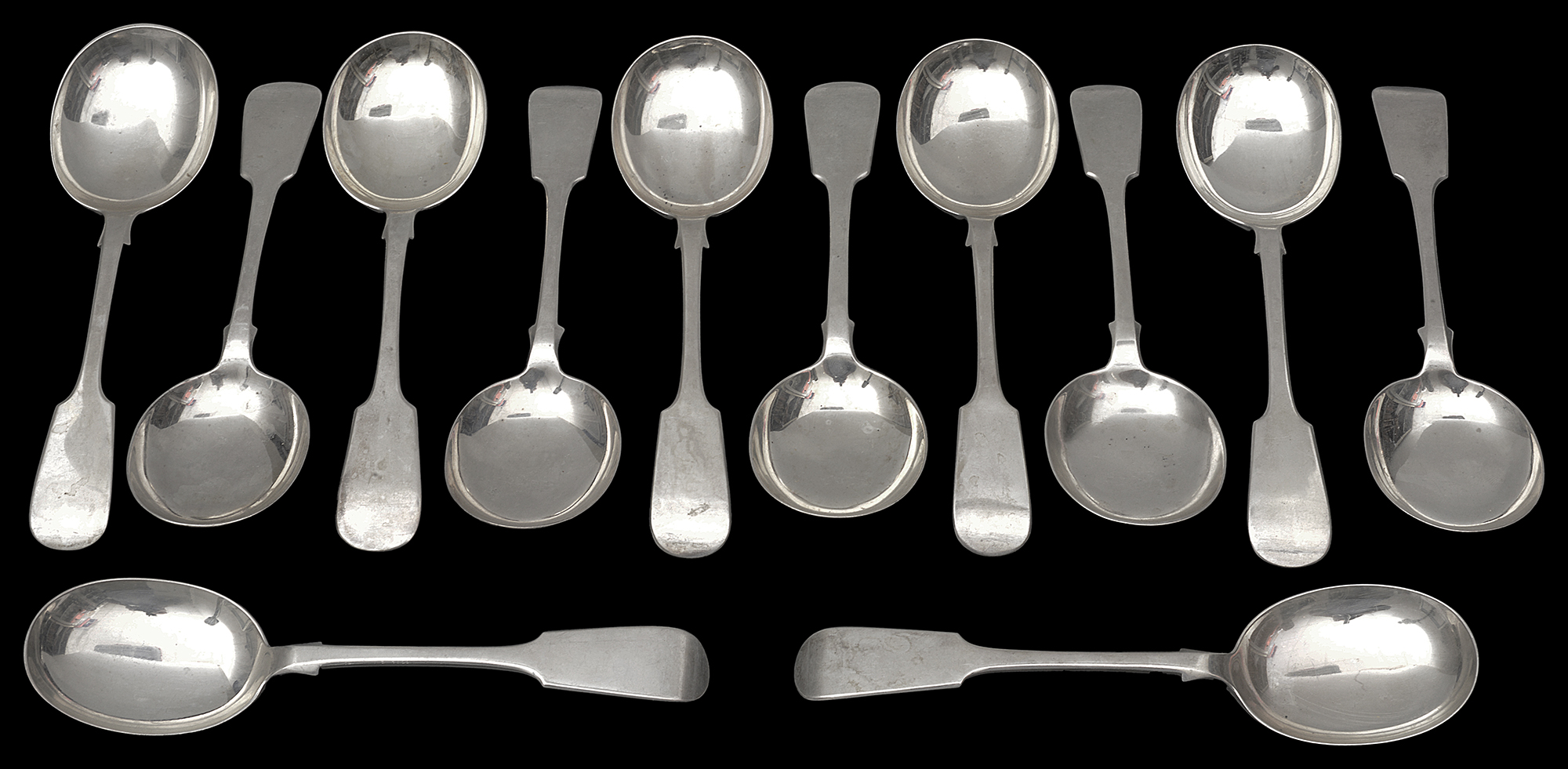 A matched set of twelve Edward VII / George V silver fiddle pattern soup spoons