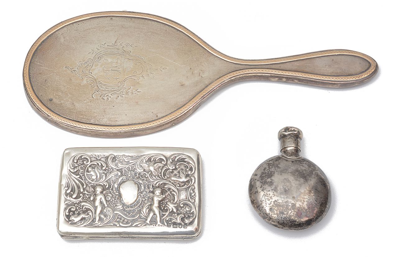 A late Victorian silver cigarette case, a George V silver hand mirror and a scent bottle