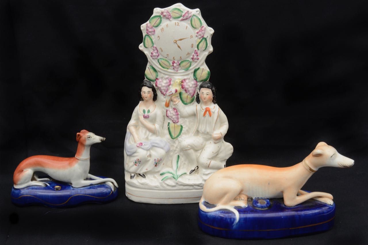 Two 19th c. Staffordshire recumbent greyhound pen stands and flatback clock group, (3)