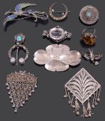 A collection of various silver brooches
