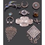 A collection of various silver brooches