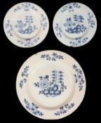 A mid 18th century English Delft charger and a matching pair of plates c.1760