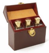 A French leather cased travelling set of three silver gilt mounted scent bottles