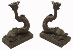 A pair of Wedgwood black basalt dolphin candlesticks