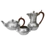 An Arts and Crafts pewter three piece tea service