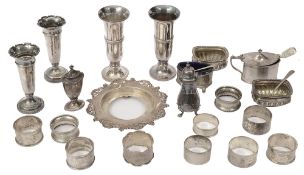 A collection of Victorian and later cruet items, spill vases and napkin rings