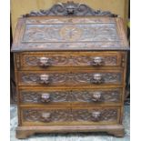 Late 19th / early 20th century heavily carved fronted oak fall front writing bureau, with fitted