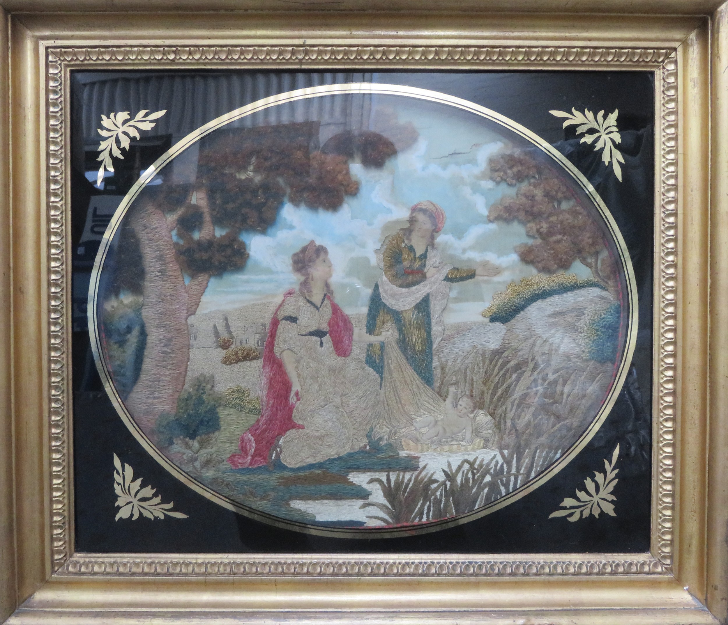 Gilt framed and glazed 19th century embroidered silk oval panel depicting Moses in the bulrushes.