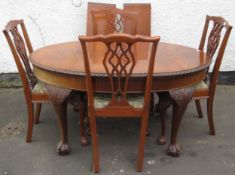 Early 20th century piecrust edged mahogany wind out extending dining table with two leaves, and four