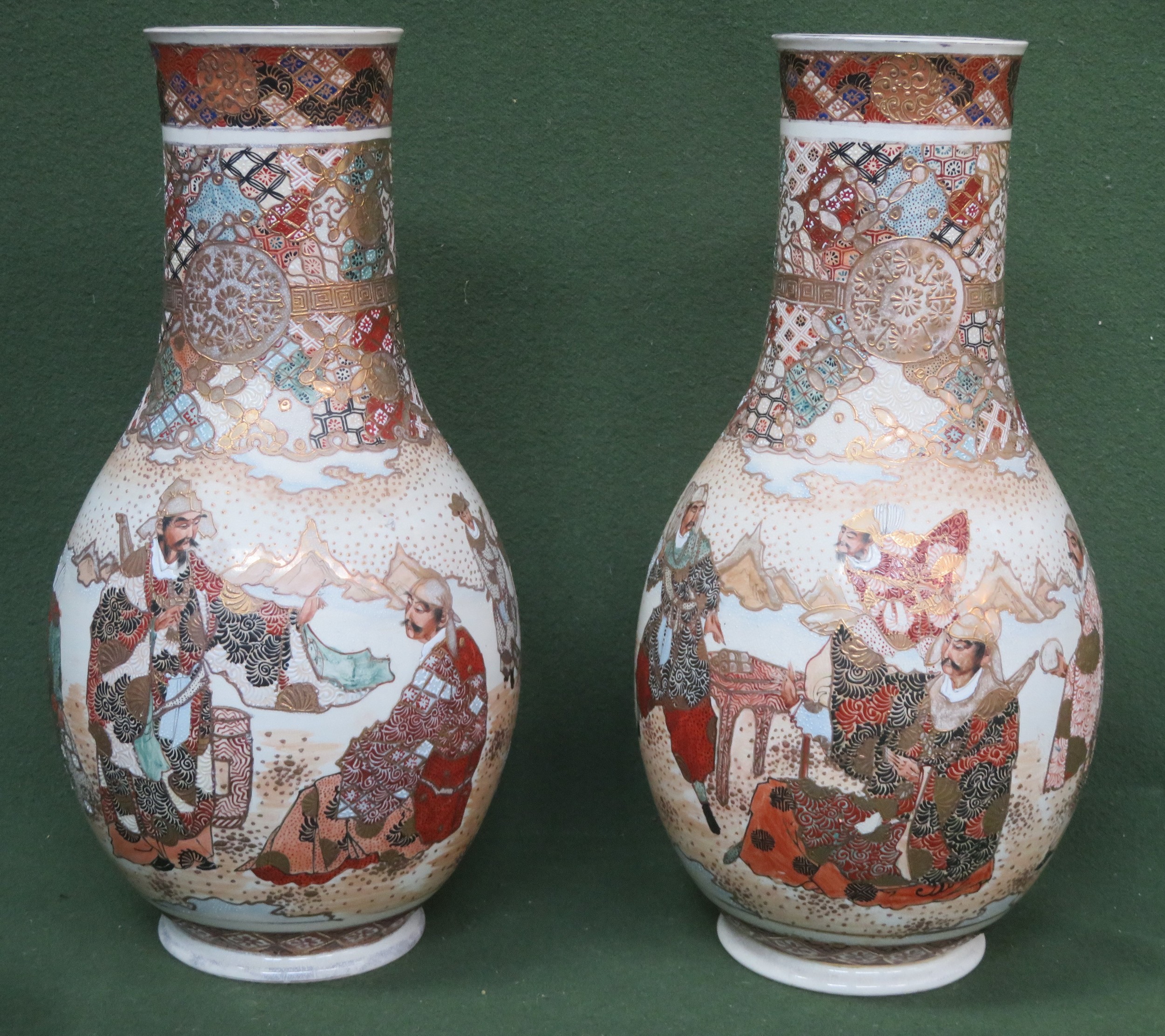 Pair of heavily gilded hand painted ceramic vases, decorated with oriental figures throughout.