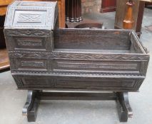 19th century heavily carved oak Jacobian style cradle, with hinged canopy, on stand.