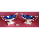 PAIR OF GEORGE III HALLMARKED SILVER NAVETTE FORM TWO HANDLED OPEN SALTS WITH BLUE GLASS LINERS,