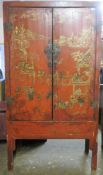 LATE 19TH/EARLY 20TH CENTURY ORIENTAL RED LACQUERED TWO DOOR STORAGE CABINET WITH GILDED DECORATION.