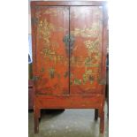 LATE 19TH/EARLY 20TH CENTURY ORIENTAL RED LACQUERED TWO DOOR STORAGE CABINET WITH GILDED DECORATION.