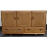 Ercol mid 20th century light oak three door sideboard with two drawers below. Approx. 76cm H x 129cm