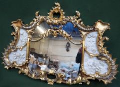 Impressive heavily gilded and ornately decorated sectional wall mirror, with relief floral panels to