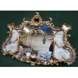 Impressive heavily gilded and ornately decorated sectional wall mirror, with relief floral panels to