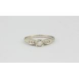 A 9ct white gold diamond set solitaire ring with diamond set shoulders, (R).