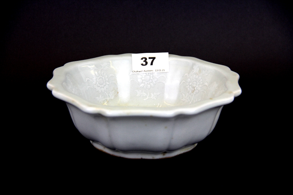 An interesting Chinese incised white ad celadon glazed porcelain bowl decorated with a central