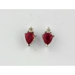 A pair of 14ct white gold stud earrings set with pear cut rubies and diamonds, L. 0.7cm.