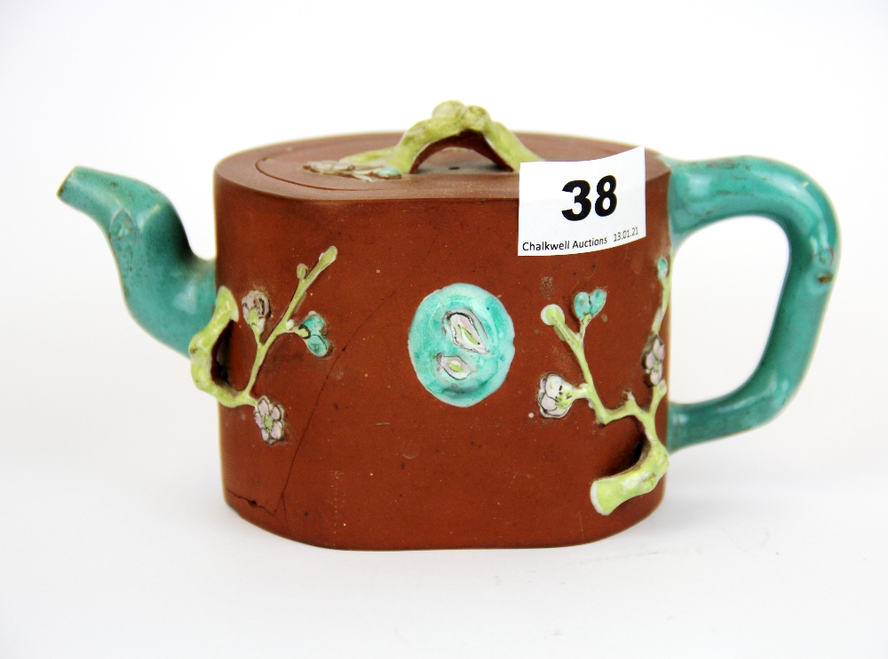 A Chinese hand painted and relief decorated terracotta teapot. Condition: A/F.