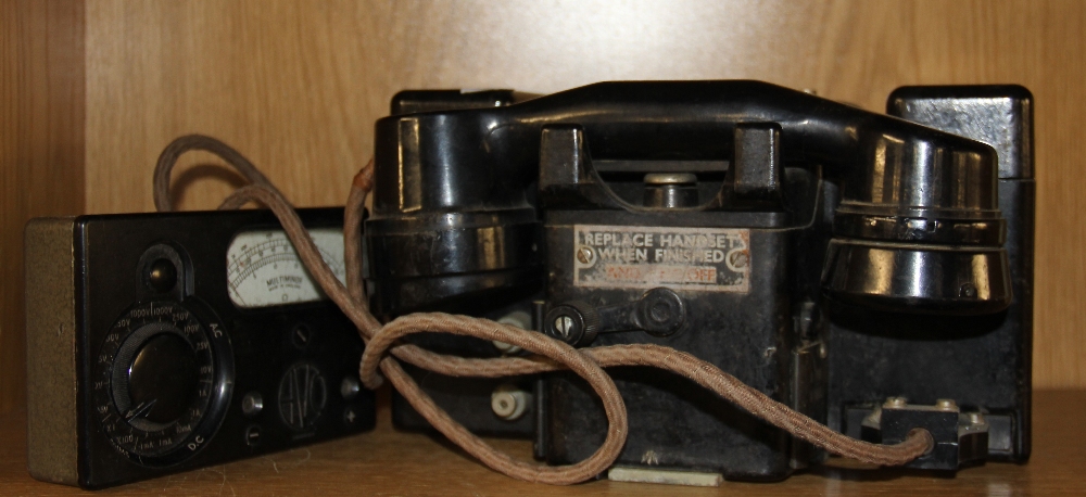 An early field telephone together with a voltmeter.