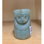 An unusual Chinese carved pale celadon russet jade cylinder decorated with two mask like faces, H.