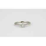 A Jenny Packham 18ct white gold oval cut diamond set solitaire ring with diamond set shoulders,