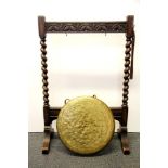 An oak framed brass gong with turned oak hammer, H. 94cm. Gong Dia., 41cm.