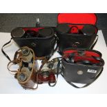 A collection of mixed binoculars and a pair of opera glasses.